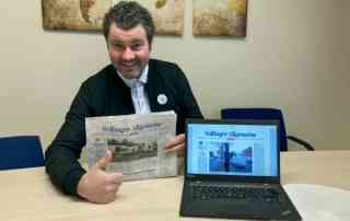 Schulleiter präsentiert die gespendete Zeitung