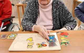 Seniorin beim Puzzeln