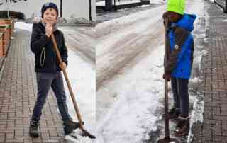 Kinderdorfkinder schippen Schnee in der NAchbarschaft