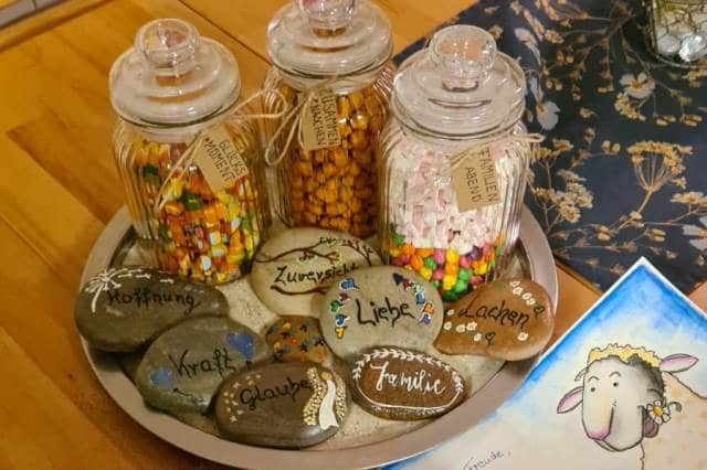 Süßigkeiten in schönen Gläsern verpackt und Botschaften auf Steine geschrieben